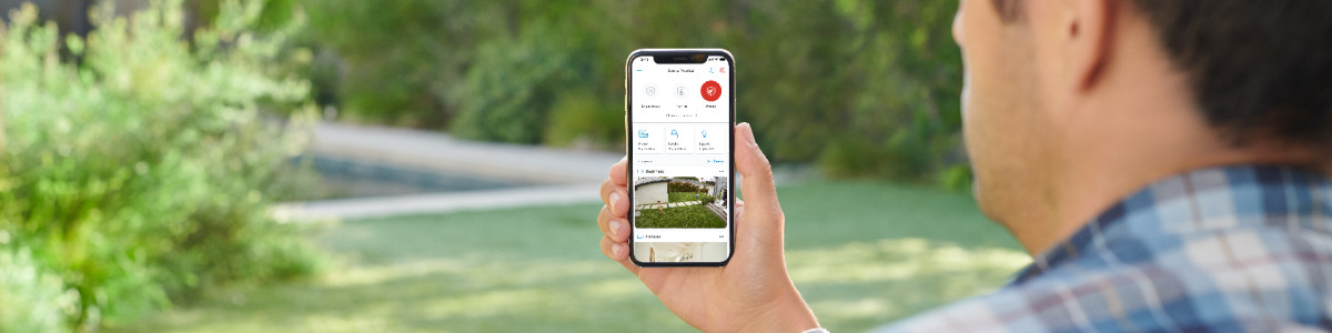 A homeowner outside their home reviewing their Ring account in the Ring app.