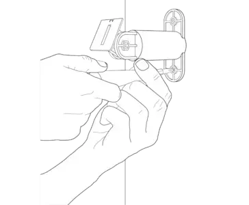 A hand holding a screwdriver and tightening the screw on the base of the mounting arm to secure it to the wall.