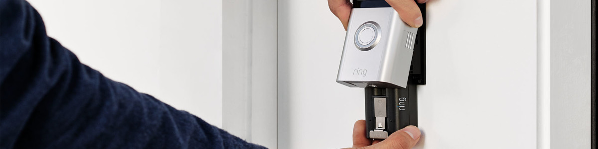 A homeowner installing Ring Video Doorbell 4 who is sliding in the Quick-Release rechargeable battery