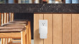 A Ring Alarm Range Extender plugged into an outlet under a kitchen island