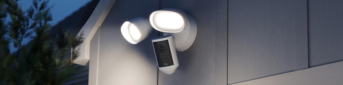 Ring Floodlight Cam Pro (2nd Gen) Installed on the exterior of a modern home with the floodlights illuminated.
