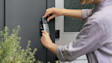 Hands installing a Wired Video Doorbell Pro (3rd Gen) on modern gray door