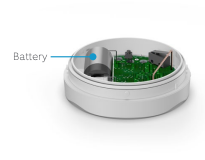 Flood & Freeze Sensor with the cover off showing the inside with a battery on the left in the compartment and a blue line pointing to it. 
