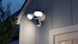 Ring Floodlight Cam Pro (2nd Gen) Installed on the exterior of a modern home with the floodlights illuminated.