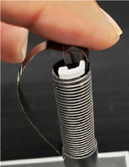 Finger inserting a replacement cable into a door view tube.
