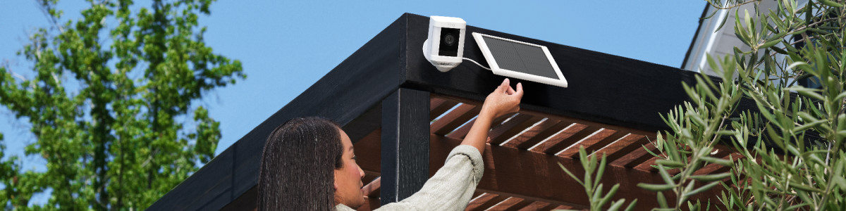 A homeowner making final installation adjustments their new Ring Spotlight Cam Plus Solar