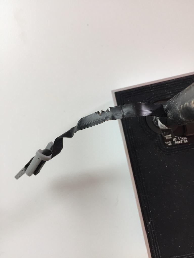 Damaged flex cable protruding from the peephole cam. 