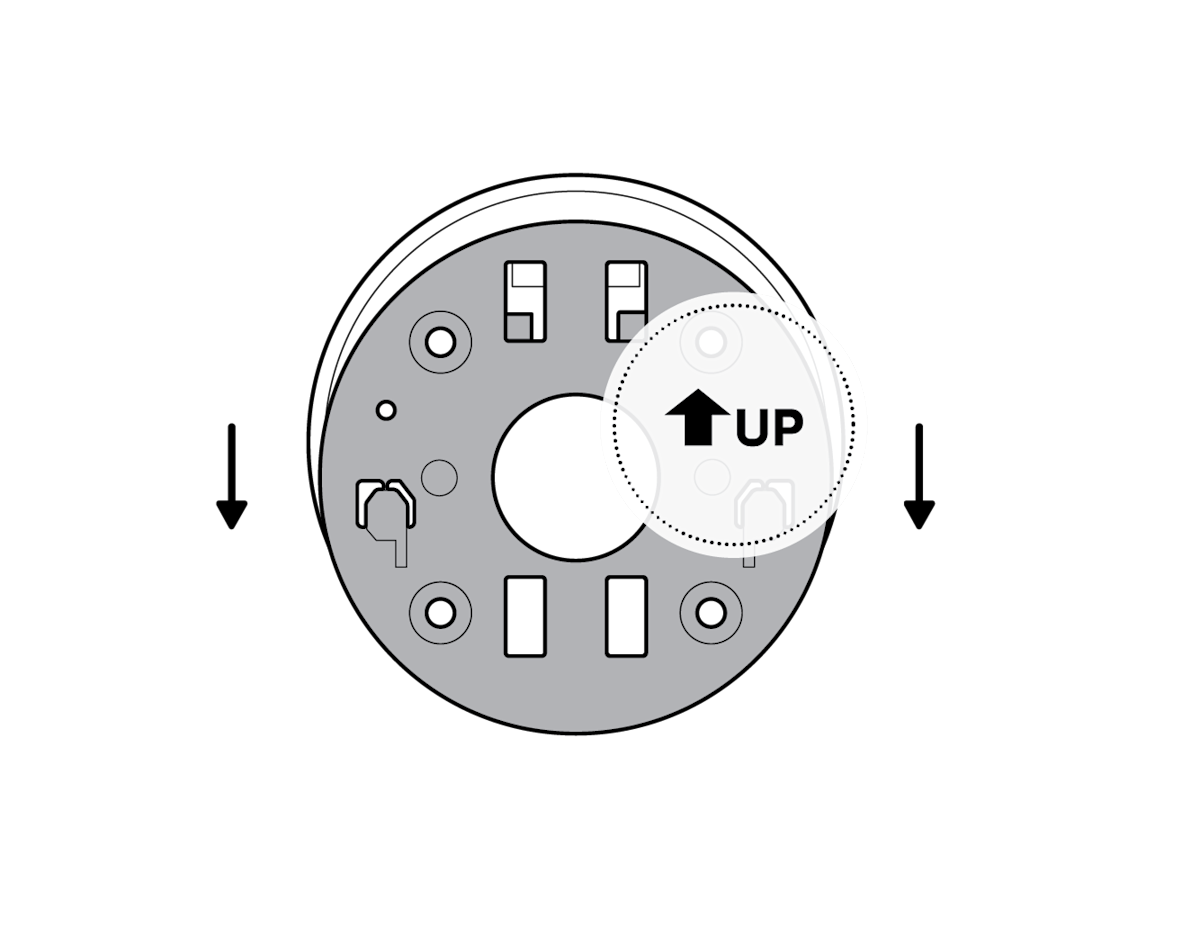 Illustration of how to remove the mounting plate by sliding it in the opposite direction of the UP arrow.