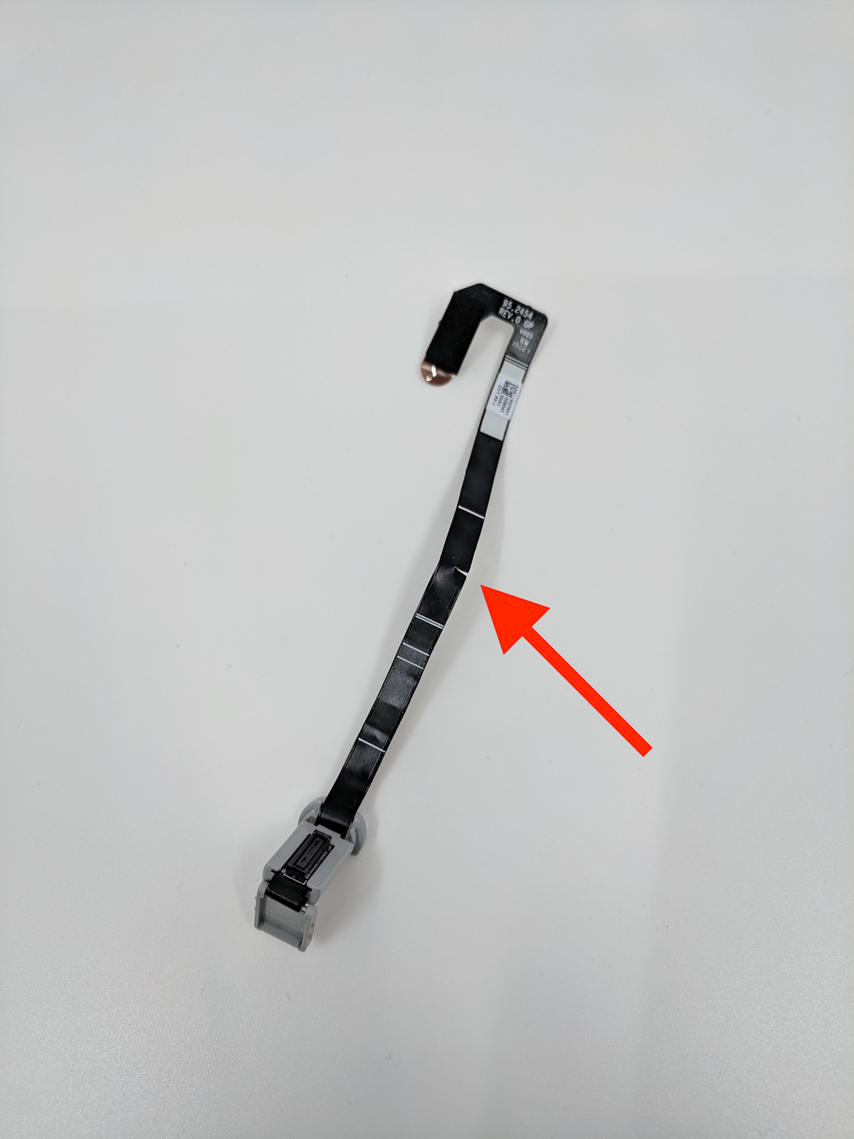 Red arrow pointing to a partial tear in the flex cable. 