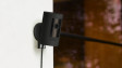 A black Ring Stick Up Cam Plug-In (3rd Generation) mounted on a wall outside ready to protect