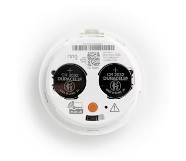 The back of Panic Button (2nd Gen) showing two CR2032 batteries inserted with the plus side facing up and a QR code and a barcode above the batteries. 