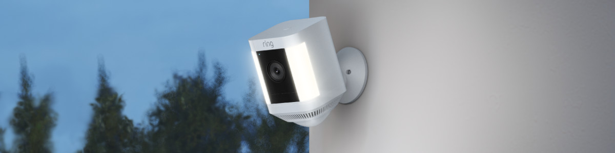 Ring Spotlight Cam Plus Battery mounted on a wall outside lighting up the night