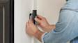 Hands installing a Wired Video Doorbell Plus (2nd Gen) on white wall
