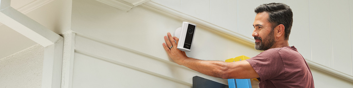 Ring Spotlight Camera (2nd Gen) being mounted on the exterior siding of a modern home.