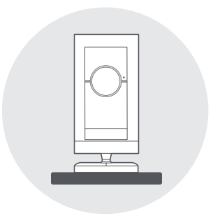 Illustration of a Stick Up Cam facing front sitting on a shelf or table.